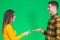 Two people playing rock paper scissors isolated on green background.