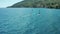 Two people practicing a windsurfing on waves, in the sea near the coast in summer. Sailboarding is an extreme sport