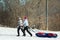 Two People Pull a Big Snow Tube. Family Vacation Snow Tubing Sport Concept