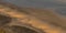 Two people on the shore of Blacks Beach at sunset