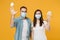 Two people in sterile face masks throw out napkin isolated on yellow background studio. Epidemic pandemic rapidly