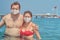 Two people in surgical masks in water of sea