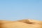 Two people walking in desert dunes