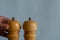 Two peppermills and a hand on a blue background