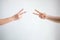 Two person playing rock paper scissors with both posturing scissors symbol on white background