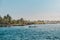 Two persons in small motorboat on ocean with tropical palm tree