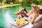 Two persons using tech gadgets by the pool