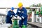 Two petrochemical workers inspecting pressure valves on a fuel tank