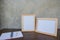 Two photo Frame on a wooden table and book on Gray wall background .