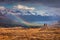 Two photographers takes picture in a light rain and rainbow in t