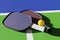 Two pickleball paddles and a ball on the court. Close-up 3D rendering