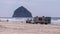 A two pickup trucks pulling a large RV trailer stuck on a beach of Cape Kiwanda