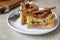 Two pieces of apple pie with cinnamon on a plate, light concrete background. Semolina cake with apple and spices. Homemade mannik