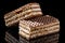 Two pieces of brown and white puff waffle cakes with boiled condensed milk isolated on black background with reflection on glossy