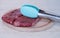 Two pieces of fresh red raw meat lie on a wooden board. On top are the meat tongs. Cooking beef steak. Close-up