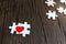 Two pieces of puzzle forming red heart on wooden, heart on pieces of jigsaw, romantic background for