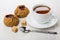 Two pies with lingonberry, tea, sugar cubes, teaspoon on table