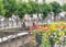 Two pigeons sit on the fence near the flowers. City embankment