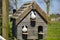 Two pigeons are sitting in their wooden feeder