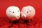 Two piggies bank in love standing on red background with red shining heart glitters