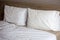 Two pillows on the bed.Messy bed with morning light. Just wake up.White pillows on a bed Comfortable soft pillows on the bed