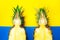 Two pineapple fruits half creative concept on blue and yellow background. Simbol of couple, love, friendship