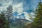 Two pines on background blue sky with clouds and Himalayan mountans