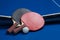 Two ping pong rackets. Table tennis rackets and a ball on a blue tennis table