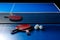 Two ping pong rackets. Table tennis rackets and a ball on a blue tennis table