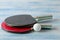 Two ping pong rackets. Table tennis rackets and a ball on a blue wooden table. sport game