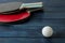 Two ping pong rackets. Table tennis rackets and a ball on a blue wooden table. sport game