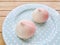 Two pink birthday peach buns on a blue plate. details.
