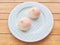 Two pink birthday peach buns on a blue plate. pastel tone.