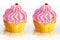 Two pink cupcake decorated with colored balls