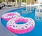 Two Pink Float Rings In A Swimming Pool