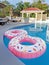 Two Pink Float Rings In A Swimming Pool