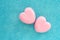 two pink glittering hearts on a blue glittering background.