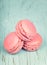 Two pink macaroons on wooden blue background