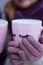 Two pink mugs with eyelashes in the hands of people