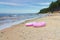 Two pink swim rings on sandy beach