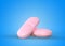 Two pink tablets on blue background