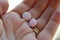 Two pink vitamin tablets or pills in palm of hand