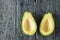 Two pitted avocado halves on a black table. The view from the top