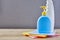 Two plastic bottle on wooden table with color cloths on gray background