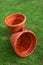 Two plastic ornamental flowerpot brown stands  on a grass