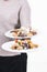 Two plates with assorted delicious looking traditional sweets being held by an out of focus female