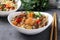 Two plates fried rice with seafood, vegetables, ginger and parsley on dark background. Asian cuisine. Vegetarian food. Closeup.