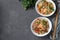 Two plates fried rice with seafood, vegetables, ginger and parsley on dark background. Asian cuisine. Vegetarian food. View from