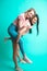 Two playful interacial girls piggybacking and having fun at studio