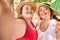 Two plus size overweight sisters twins women smiling taking a selfie picture with the phone outdoors